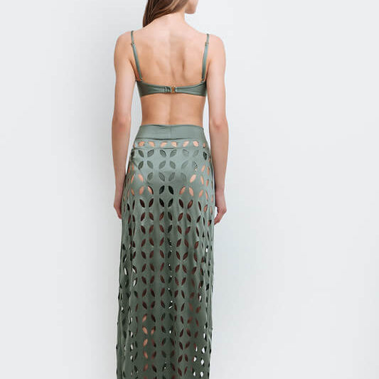 Model wearing a laser cut green skirt by Mar de Lua. She's standing in front of a white background. The purpose of the image is to highlight the skirt because it's for sale at EVAMAIA boutique in Studio City, CA.