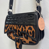 Leopard print handbag with black accents on a white background