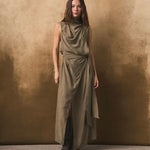 Woman wearing a long olive green dress against a textured brown background