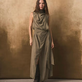 Woman wearing a long olive green dress against a textured brown background