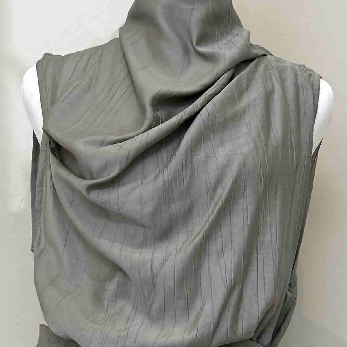 A gray draped sleeveless top or dress displayed on a white mannequin torso against a plain light background.