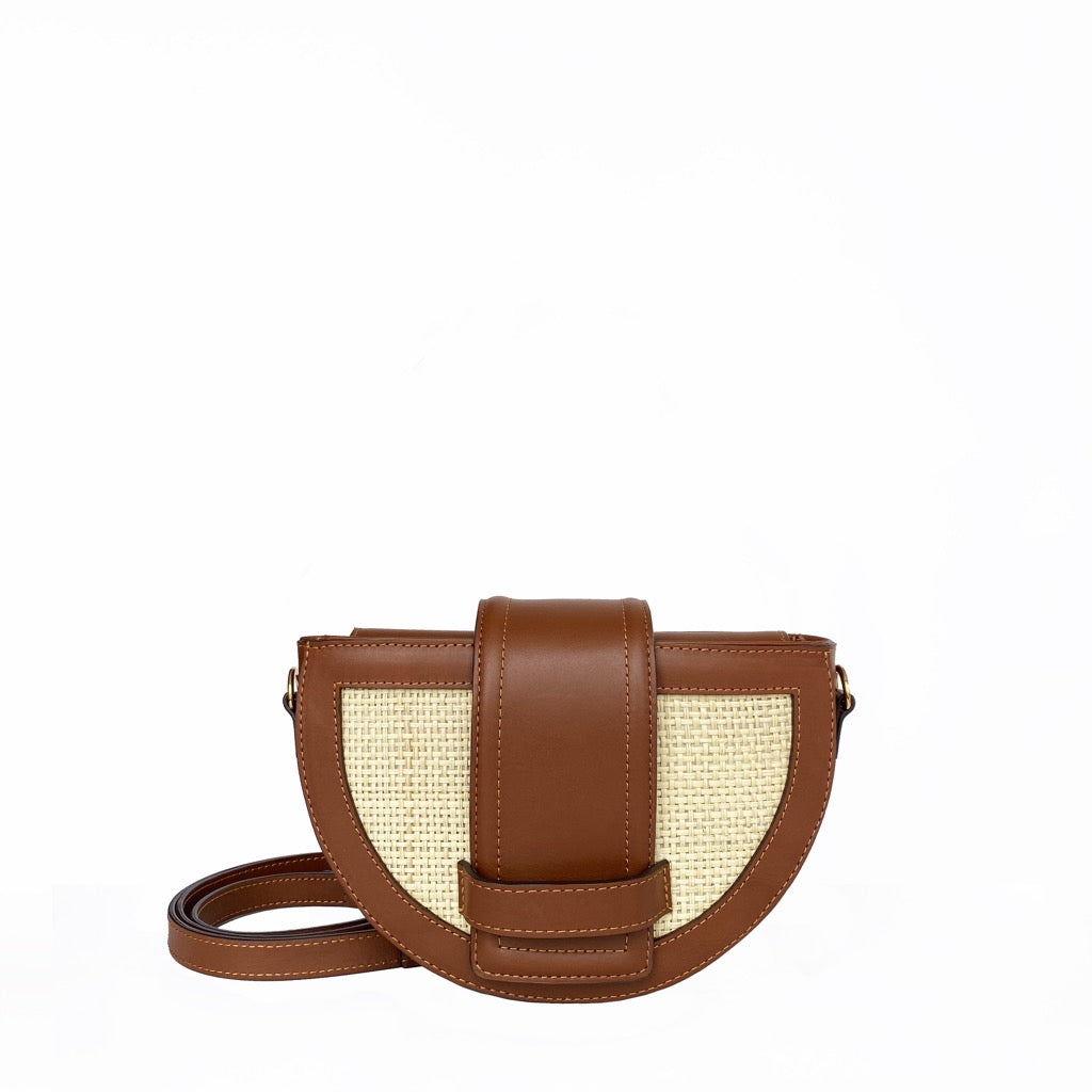 Brown crossbody bag with woven design on a white background. 