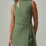 Woman wearing a green dress against a plain background