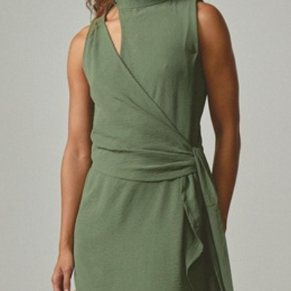 Woman wearing a green dress against a plain background