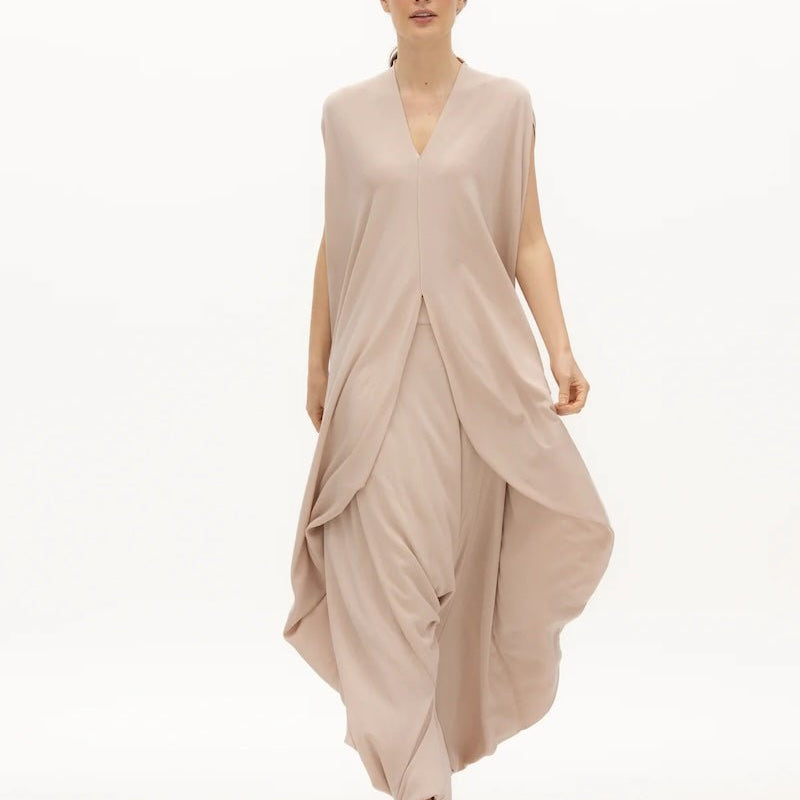 Image of woman wearing a flowy jumpsuit against a white background. The purpose of this image is to highlight the jumpsuit from NAOS, which is for sale at EVAMAIA boutique in Studio City, CA.