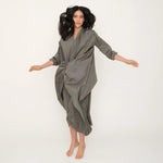 Woman wearing the green Miaroma dress against a white background
