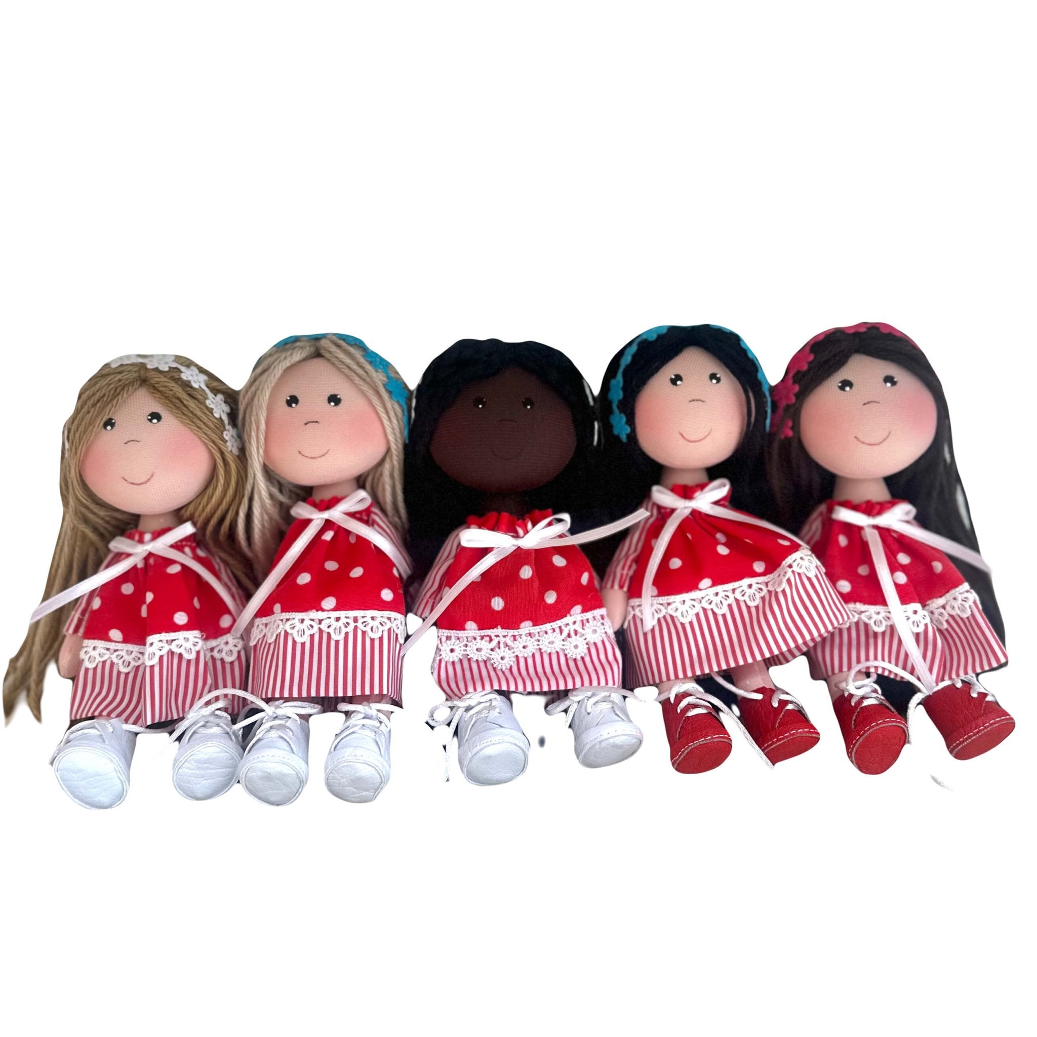 Cute rag dolls handmade in Colombia. There are 5 dolls wearing a red polka dot dress with different skin and hair colors. They are also wearing flower headbands.