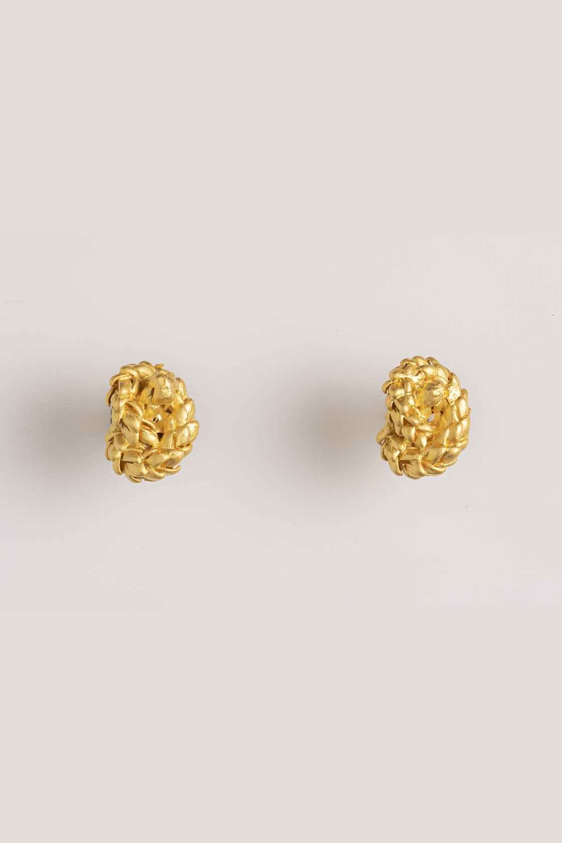 Image of gold earrings with a knot design. The purpose of this image is to highlight the earrings by Alma Jewelry. 