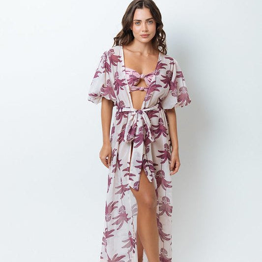 Image of a woman looking at the camera and standing on a white background. She's wearing a pink swimsuit and kimono. The purpose of this image is to highlight the mar de lua clothing.