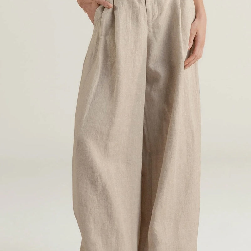 Beige wide-leg pants worn by a person on a white background.