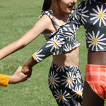 kids holding hands dancing in grass. One little girl is wearing the picnic pants with a matching crop top.