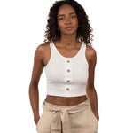 Woman wearing a white ribbed top and black bottoms. She's standing by a white background and looking at the camera. The purpose of this image is to highlight the sustainable clothing by Madre Tierra.