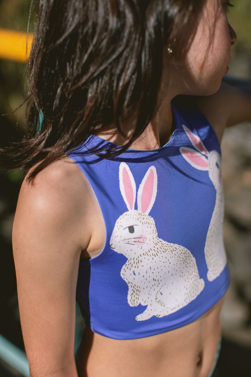 Children's blue bathing suit top with rabbit design.