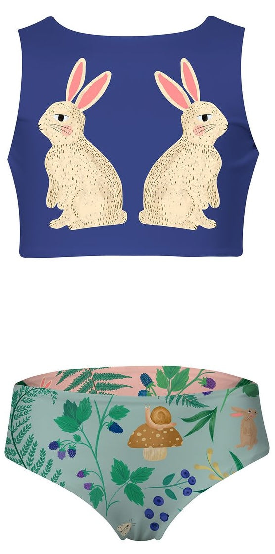 Two-piece girl's swimsuit with rabbit design on top and nature-themed bottom on a white background.