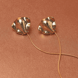 Gold sting-ray shaped earrings with accent string. 