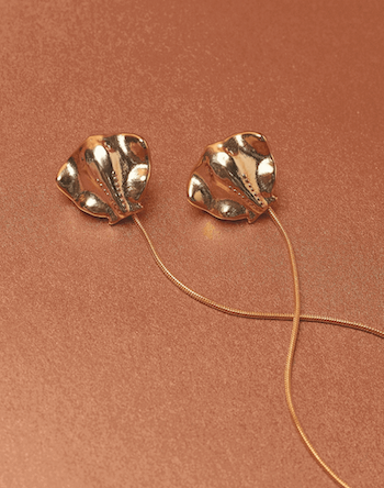 Gold sting-ray shaped earrings with accent string. 