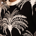 Close-up of a black and white tree palm patterned sweater.