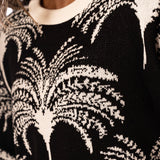 Close-up of a black and white tree palm patterned sweater.