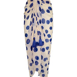 Image of a white sarong with blue polka dots. It's tied as it would be on a body. It's against a white background. The purpose of this image is to highlight the sarong, which is on sale at EVAMAIA boutique in Studio City.