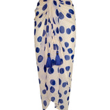 Image of a white sarong with blue polka dots. It's tied as it would be on a body. It's against a white background. The purpose of this image is to highlight the sarong, which is on sale at EVAMAIA boutique in Studio City.