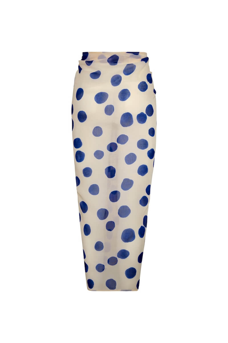 Image of a white sarong with blue polka dots. It's tied as it would be on a body. It's against a white background. The purpose of this image is to highlight the sarong, which is on sale at EVAMAIA boutique in Studio City.
