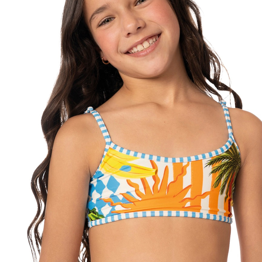Young girl wearing a colorful tropical-themed bikini top on a white background