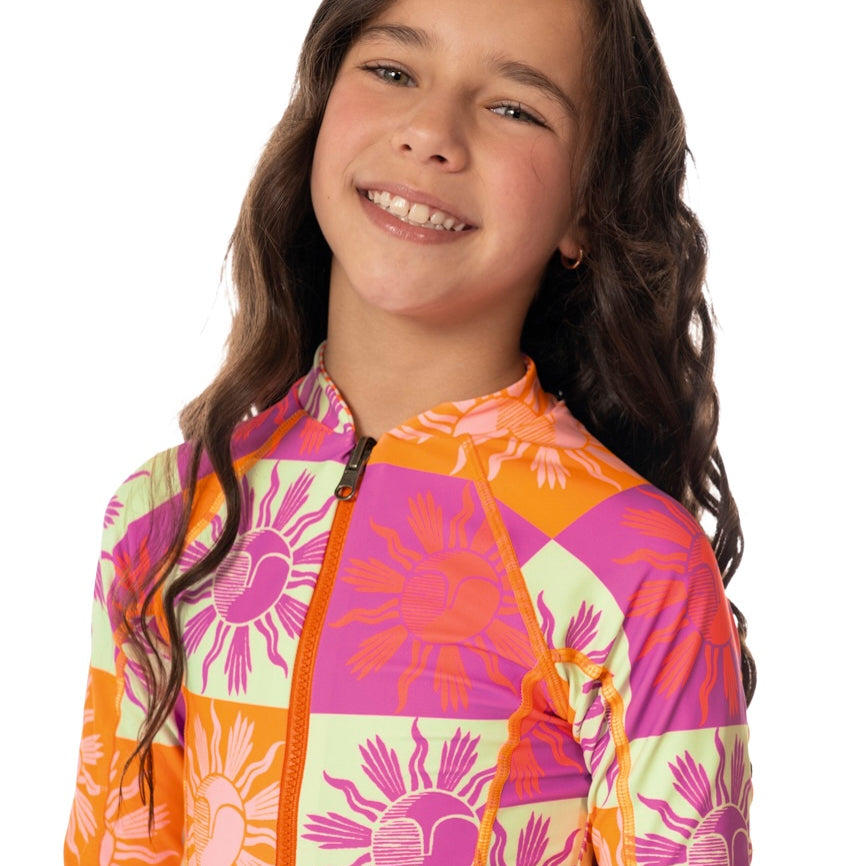 Girl wearing a colorful long sleeve  patchwork sun swimsuit on a white background