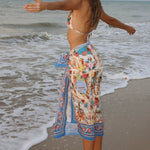 Image of a woman wearing a blue bikini and matching beachwrap on her waist. The purpose of the image is to highlight the beach cover-up by Flor Amazona.