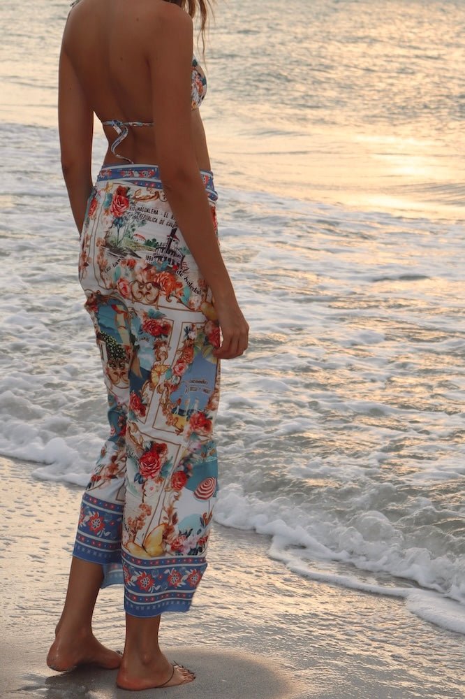Image of a woman wearing a blue bikini and matching beachwrap on her waist. The purpose of the image is to highlight the beach cover-up by Flor Amazona.