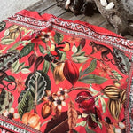 Image of a colorful cover up sitting on a wood table near the ocean. The purpose of this image is to highlight the cover up, which is made in colombia by Flor Amazona.