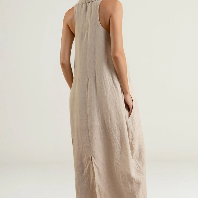Woman wearing a beige sleeveless dress against a white background.