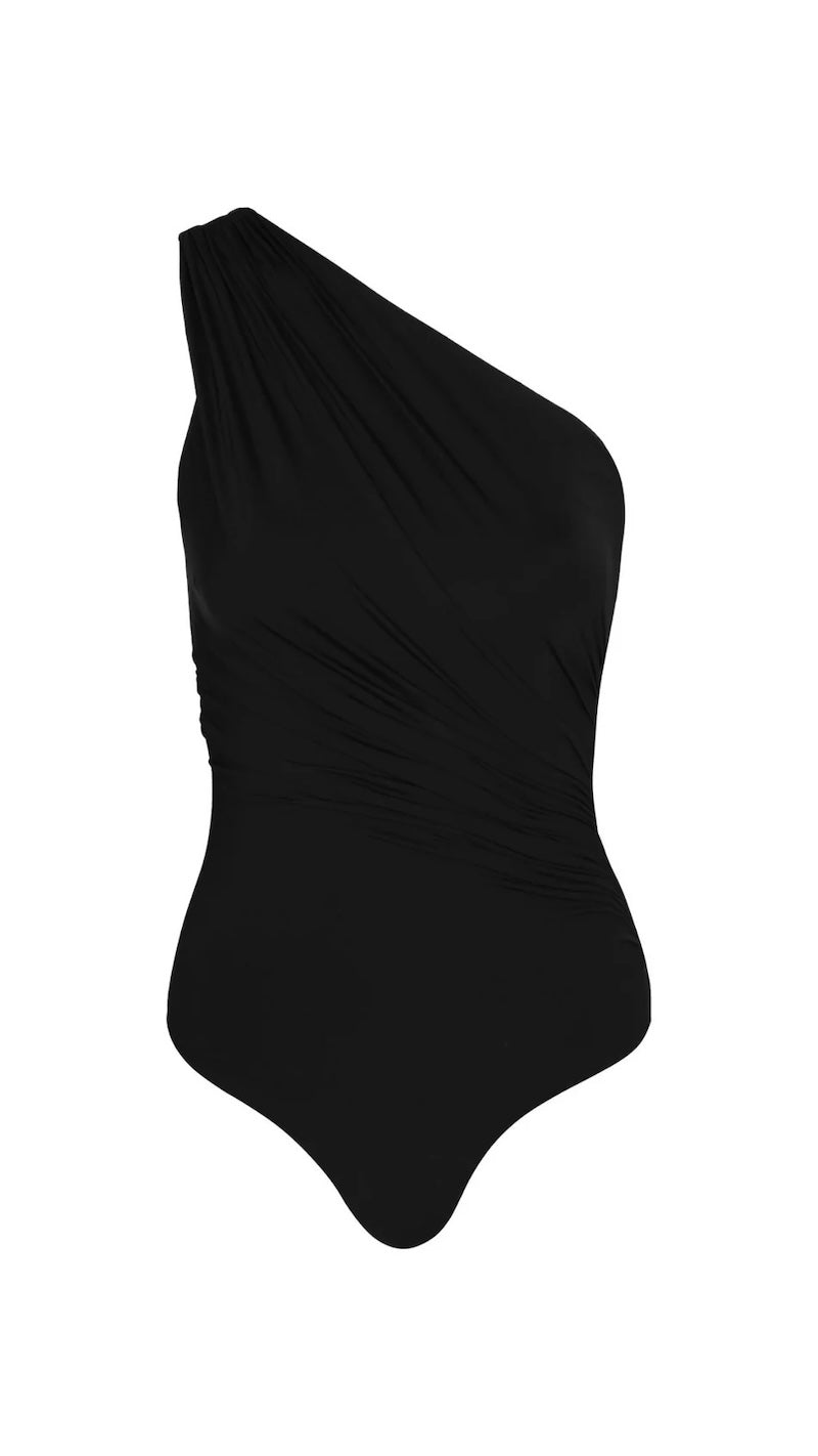 Image of a black swimsuit with draping on the front. It's a one shoulder fit. The swimsuit is on a white background. The purpose of the image is to highlight the swimsuit because it is for sale at EVAMAIA Boutique.
