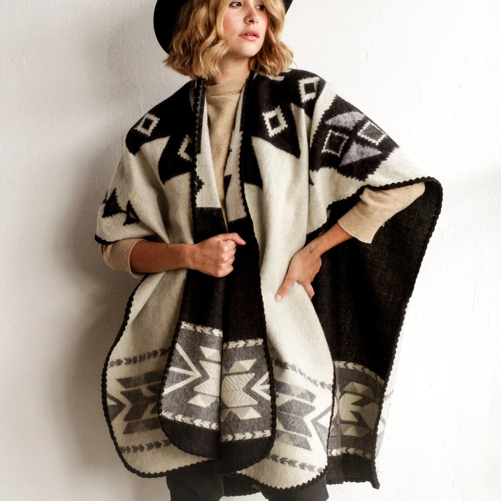 Woman wearing the Aras Poncho in Black and White by Plisse.