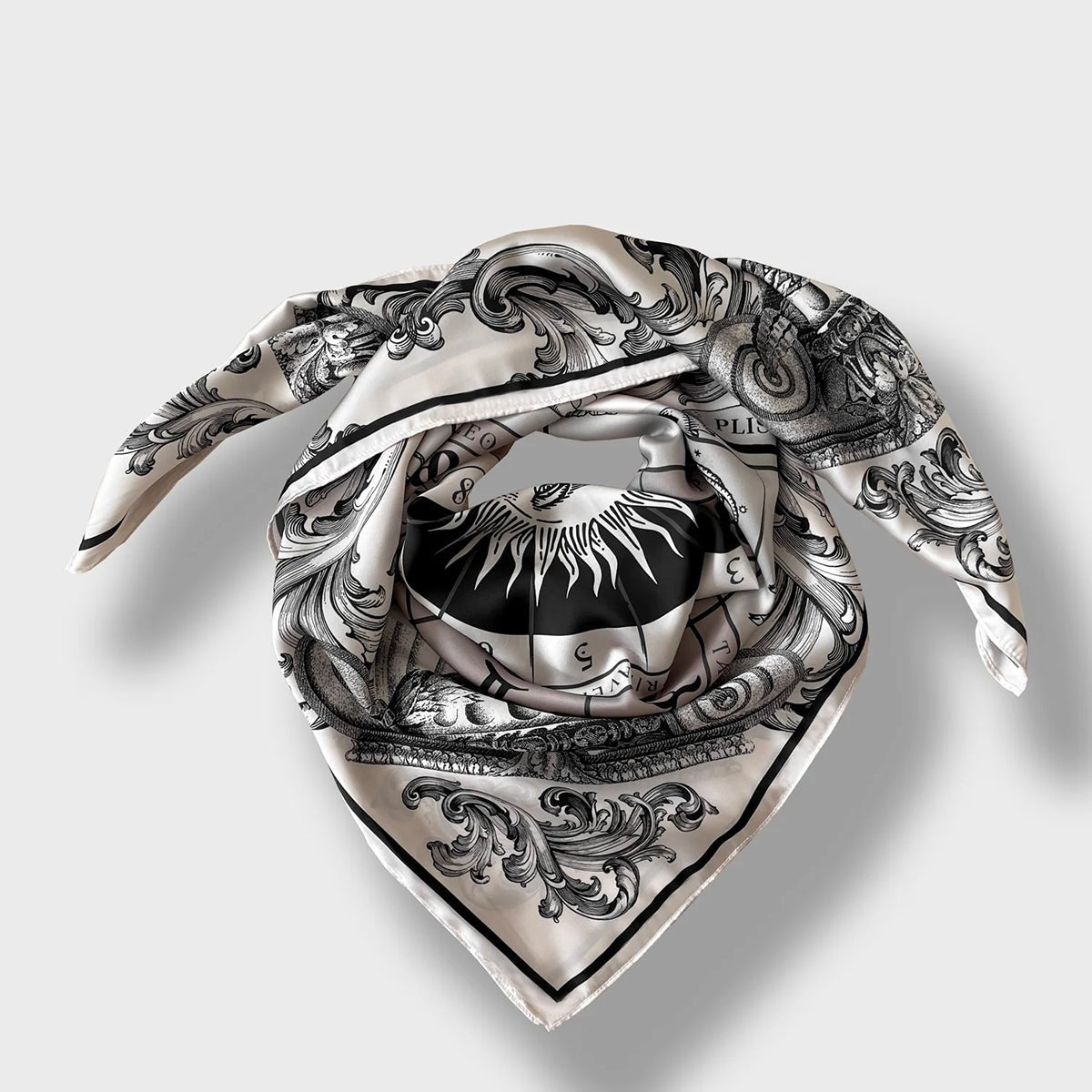 The neutral-toned Astro scarf featuring 12 zodiac signs surrounding a radiant sun wrapped as if on neck on plain background.