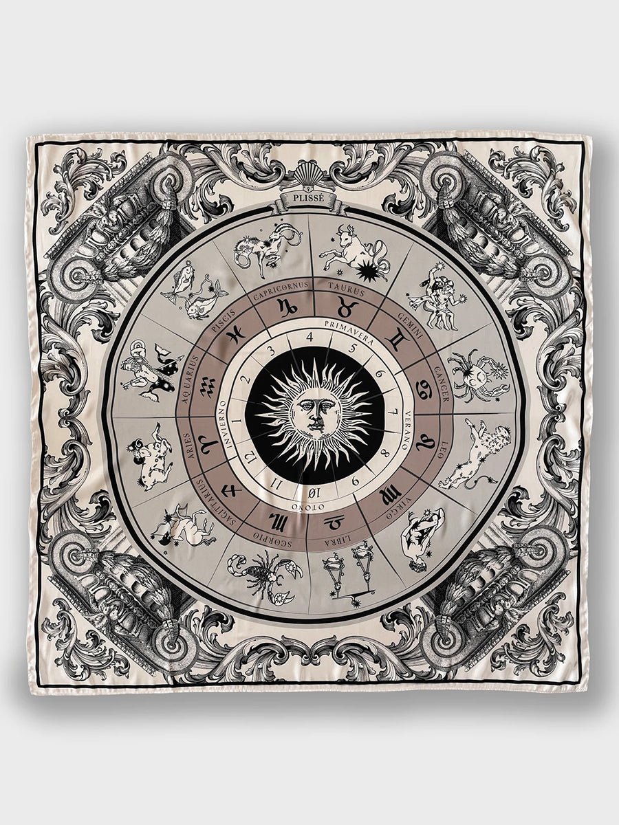 Astro Scarf by Plisse on plain background. A neutral-toned scarf featuring 12 zodiac signs surrounding a radiant sun.