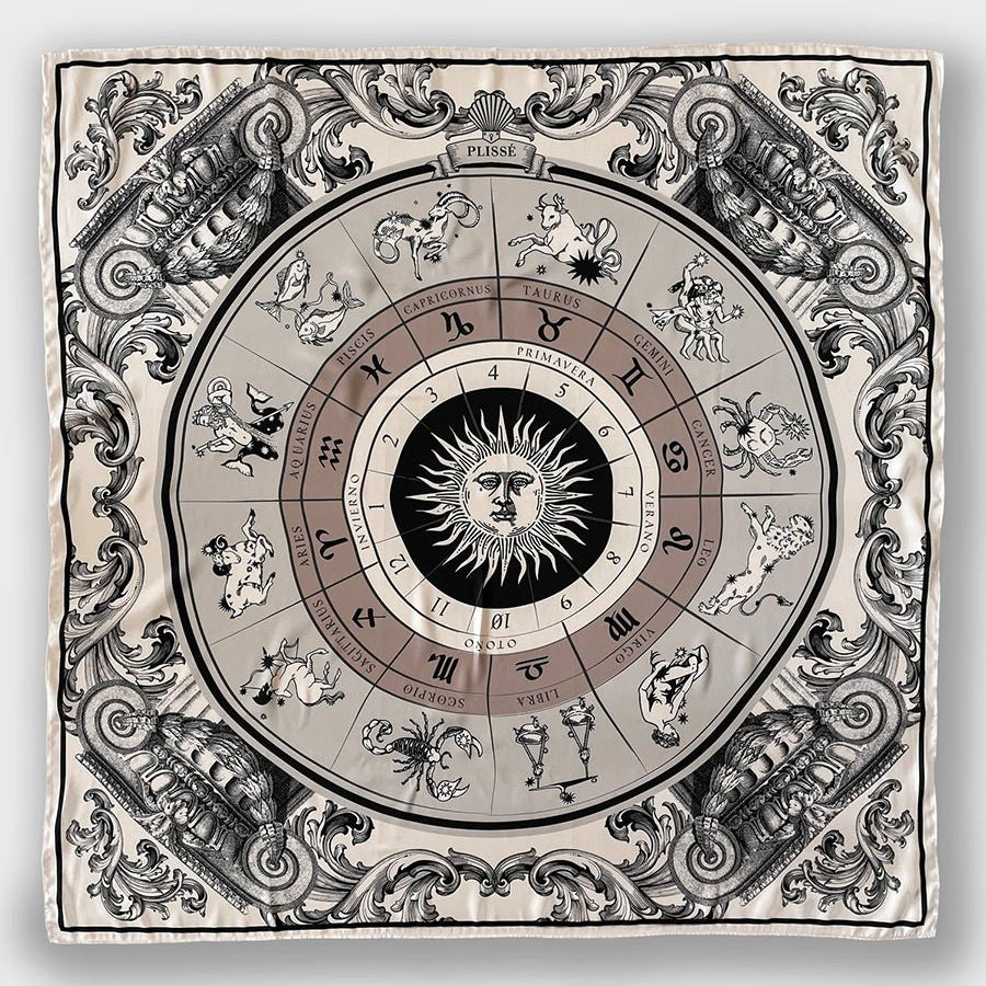 Astro Scarf by Plisse on plain background. A neutral-toned scarf featuring 12 zodiac signs surrounding a radiant sun.