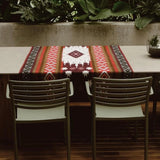 Frontera Reversible Throw Blanket placed as a table runner on an outdoor table set.