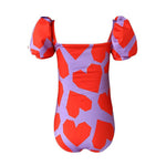 Back of Origami heart patterned puff-sleeve one-piece swimsuit for girls. It is shown over a white background.
