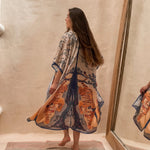 Model wearing the Kimono Bengal Tiger. She is towards the wall with a large mirror next to her. The design features a mirrored design of a large tree, nature details, and the bengal tiger.