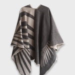 Back of grey Natura Poncho on a white background. This poncho features a color block design with leaflike pattern on the darker half. On the lighter half is ti just a small rectangle box of a leaf.