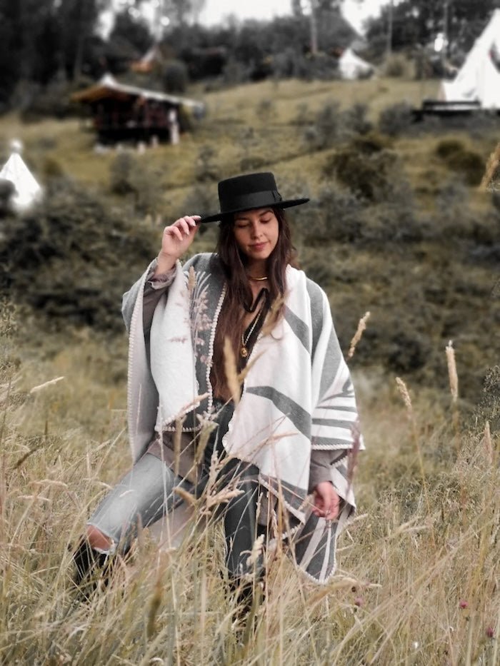 Paloma wearing grey natura poncho standing in the middle of plains.