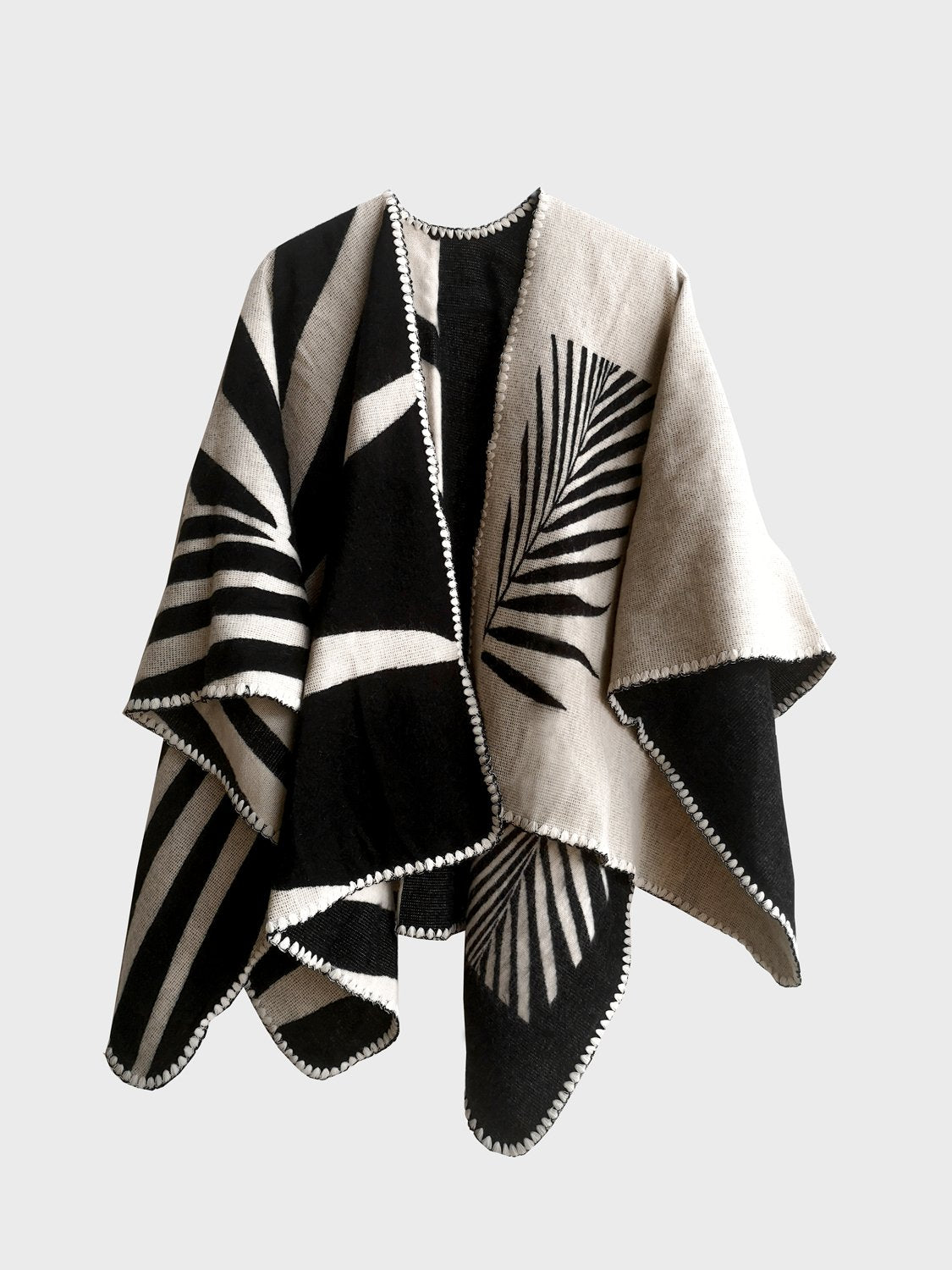 Natura Poncho on a white background. This poncho features a color block design with leaflike pattern on the darker half. On the lighter half is ti just a small rectangle box of a leaf.