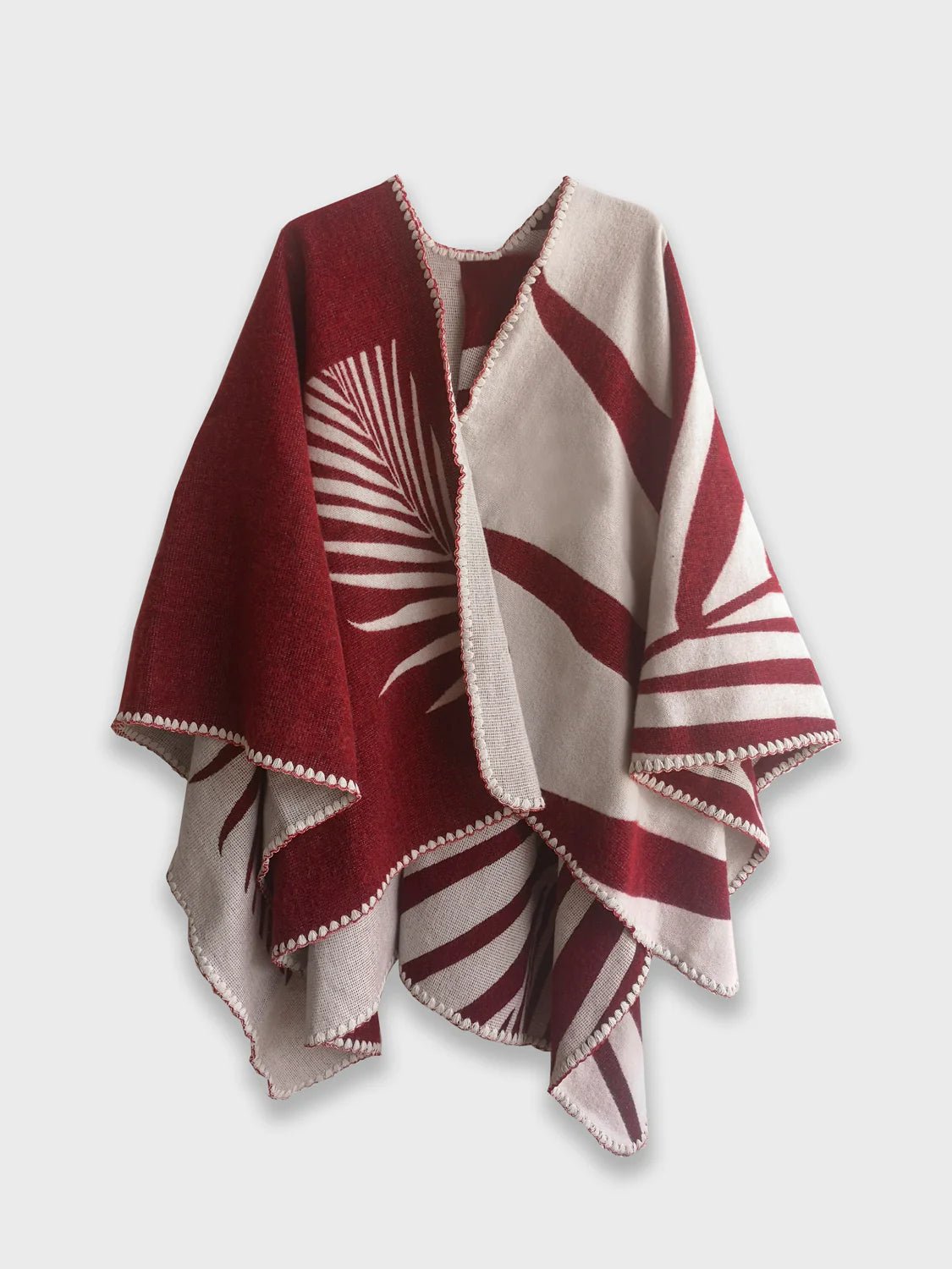 Red Natura Poncho on a white background. This poncho features a color block design with leaflike pattern on the darker half. On the lighter half is ti just a small rectangle box of a leaf.