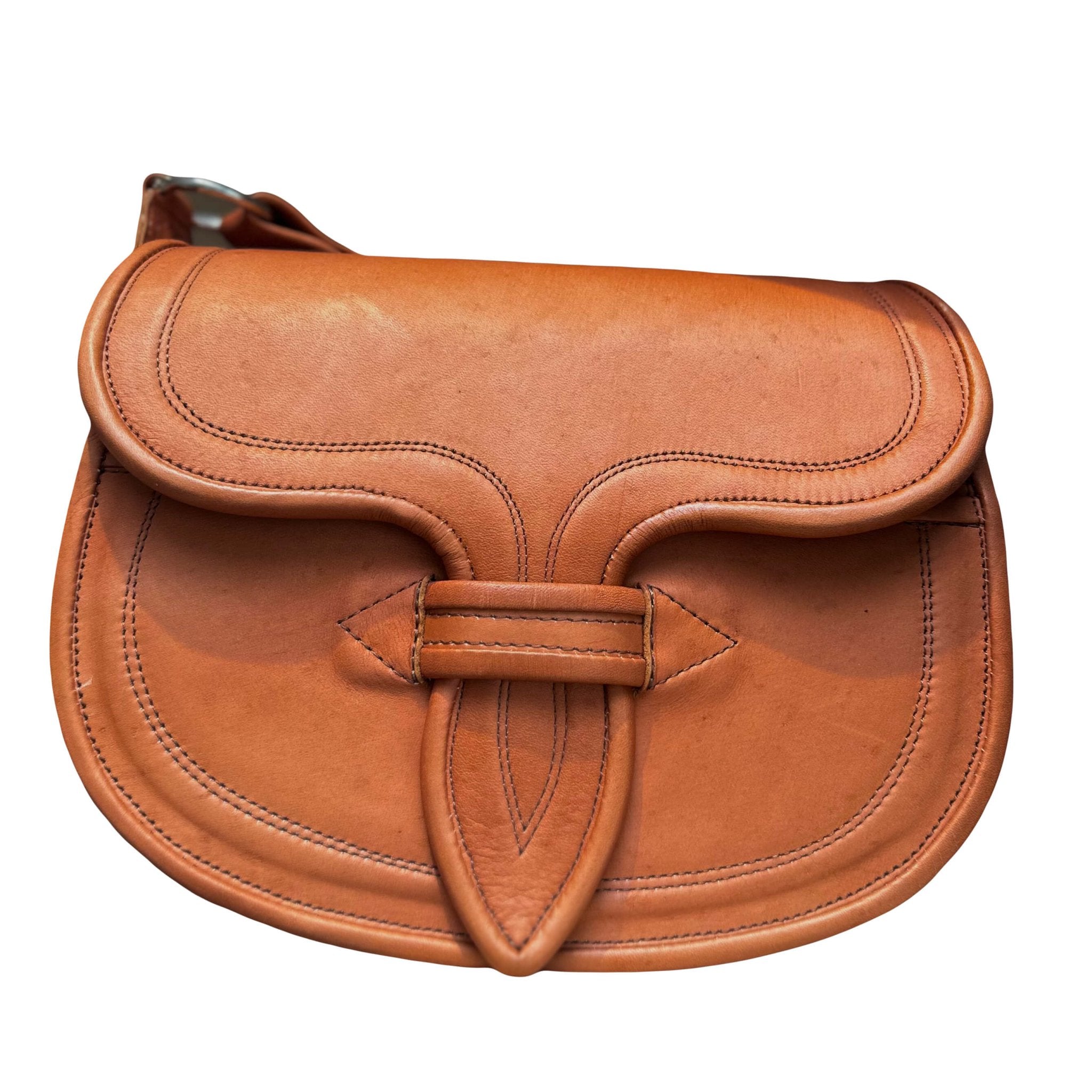 Oversized carriel crossbody bag in camel. It is a semi round bag with intricate stitching. It is displayed over a white background.