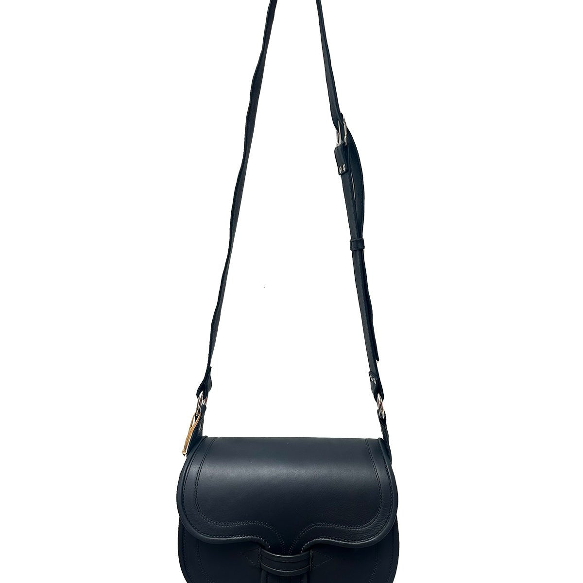 The black Oversized Crossbody Carriel Bag hanging from a hook. The bag has a flap closure with an adjustable strap.
