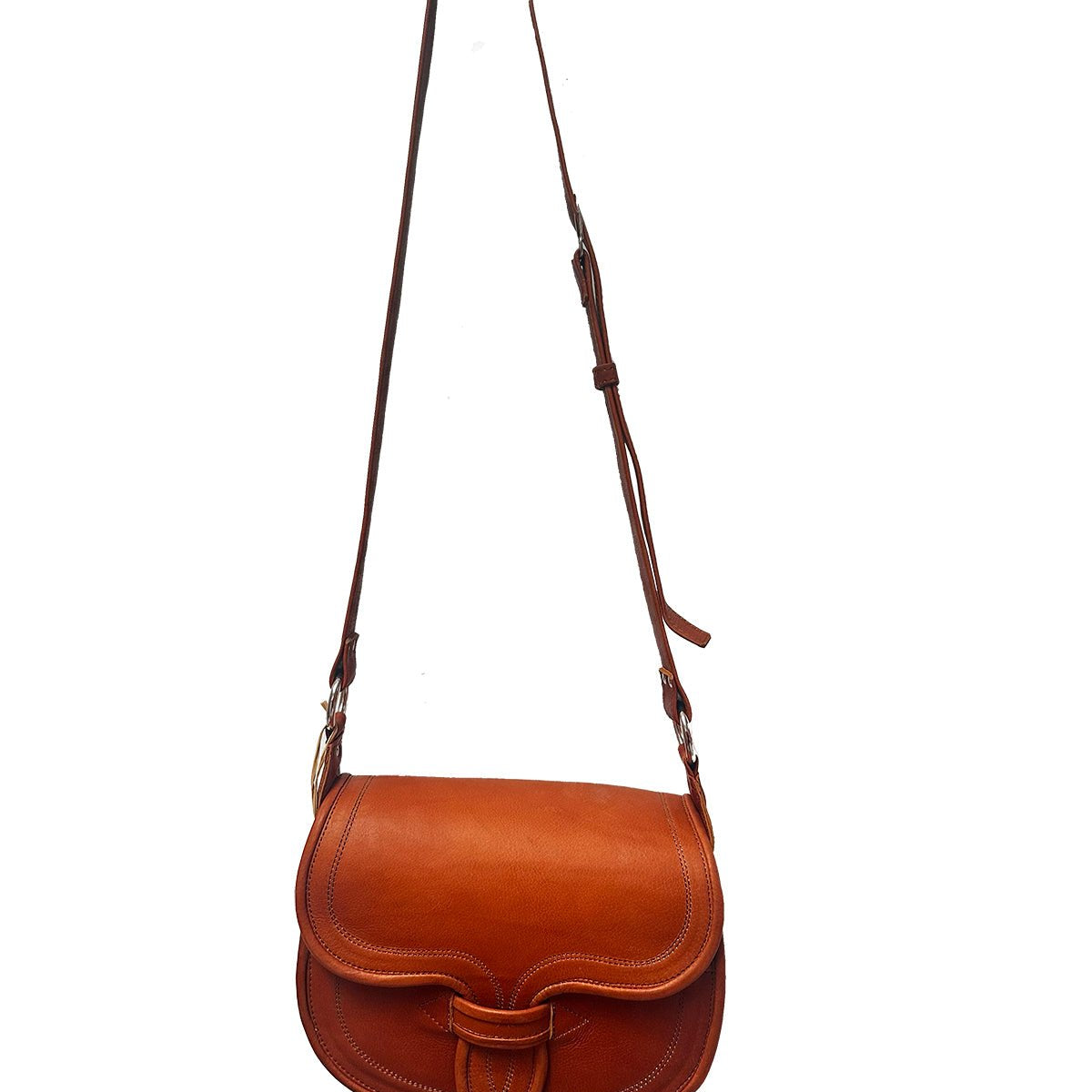 The Camel Oversized Crossbody Carriel Bag hanging from a hook. The bag has a flap closure with an adjustable strap.