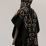 The back of the model wearing the OX Black and Grey Poncho with Hood over a plain background.