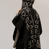 The back of the model wearing the OX Black and Grey Poncho with Hood over a plain background.