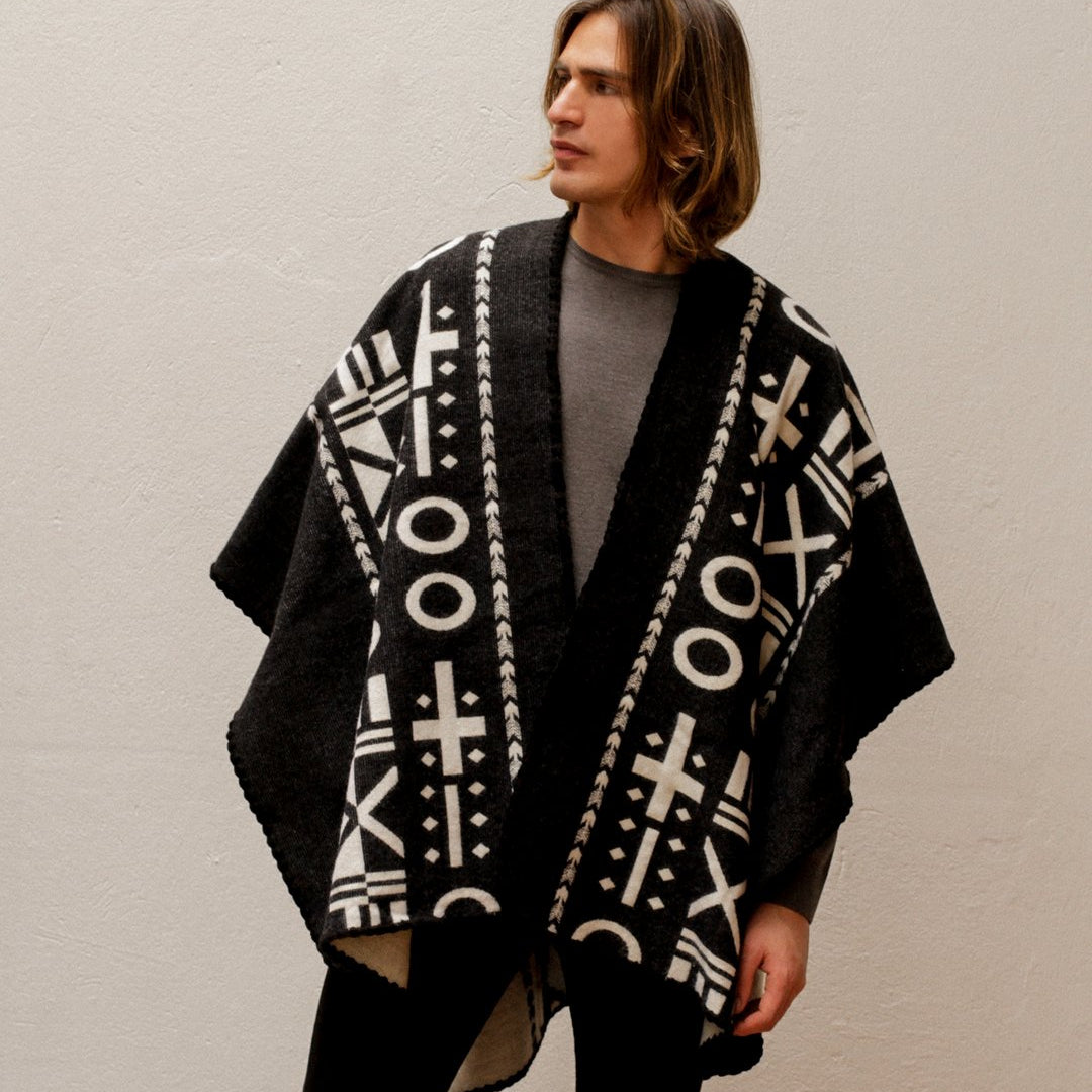 He is wearing the OX Black and White Poncho. He is wearing it on the black side paired with a light grey top, black jeans and boots.