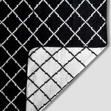 Close up of Royal Reversible Throw Blanket. Image is of  classic black and white crisscross pattern and a corner folded to white and black crisscross pattern.